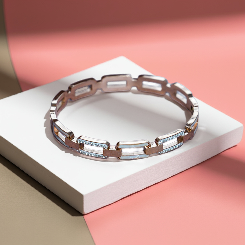 Silver bracelet with gemstones on a white platform against a pink background by hitesh bangles