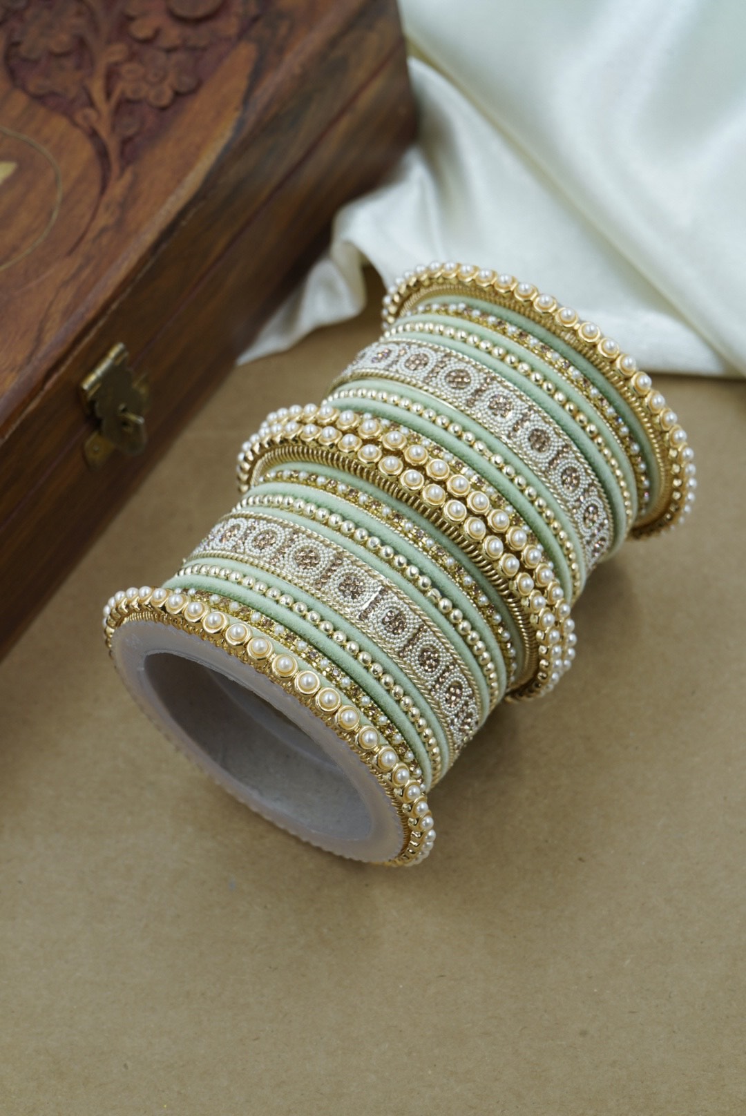 Roll of decorative ribbons with intricate patterns on a wooden surface by hitesh bangles