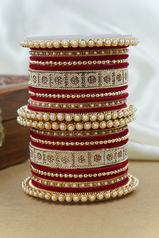 Set of pearl and red bangles stacked on a white surface by hitesh bangles