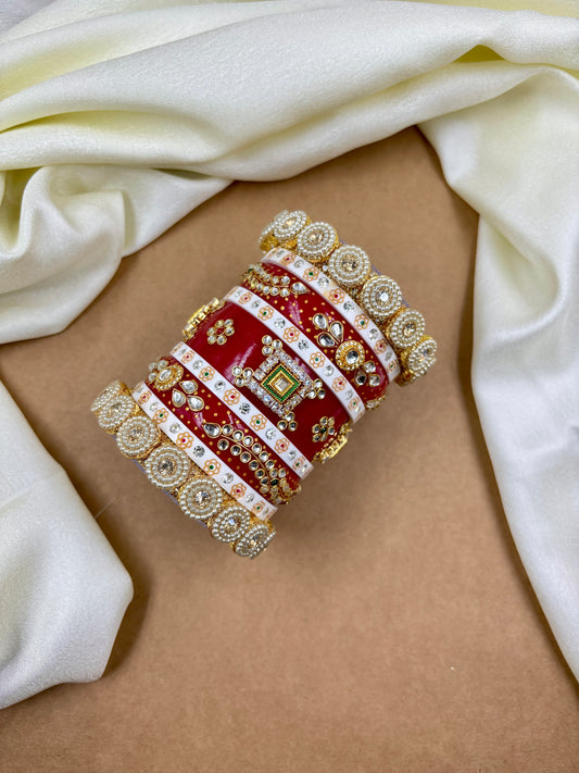 Decorative red and gold bangle on a beige surface with white fabric by hitesh bangles