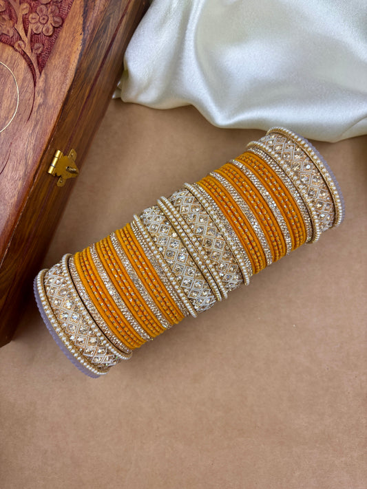 Decorative bangles with gold and silver accents on a beige surface by hitesh bangles