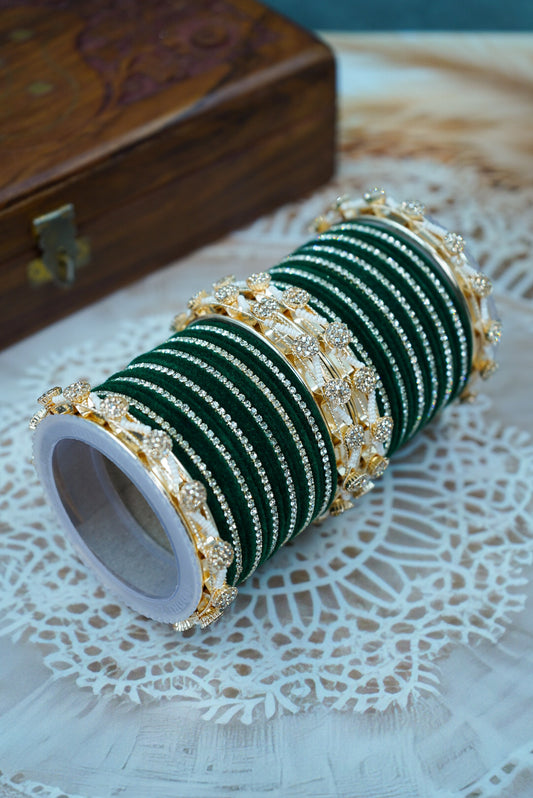 Green bangles with gold accents on a white doily, wooden box in the background by hitesh bangles