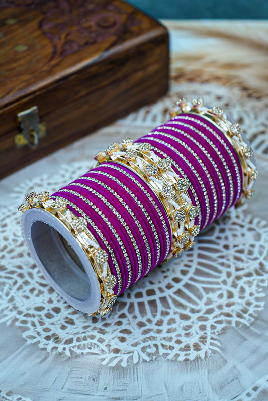 Roll of purple bangles with gold accents on a white doily by hitesh bangles