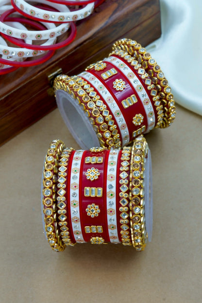 Red and gold bangles with intricate designs on a beige surface by hitesh bangles