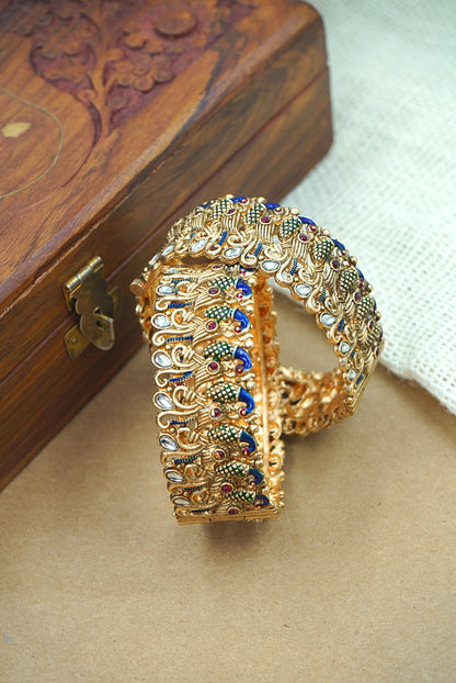 Gold bracelet with gemstones on a wooden box by hitesh bangles