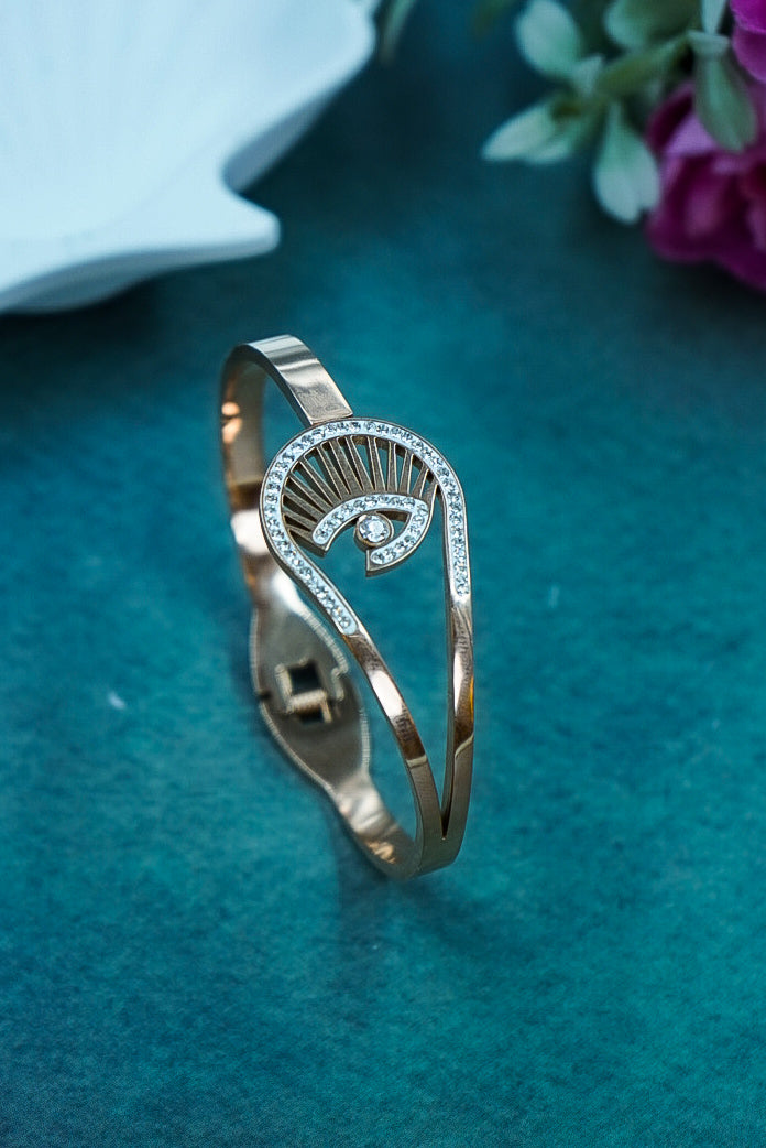 Gold bracelet with diamond accents on a teal surface by hitesh bangles