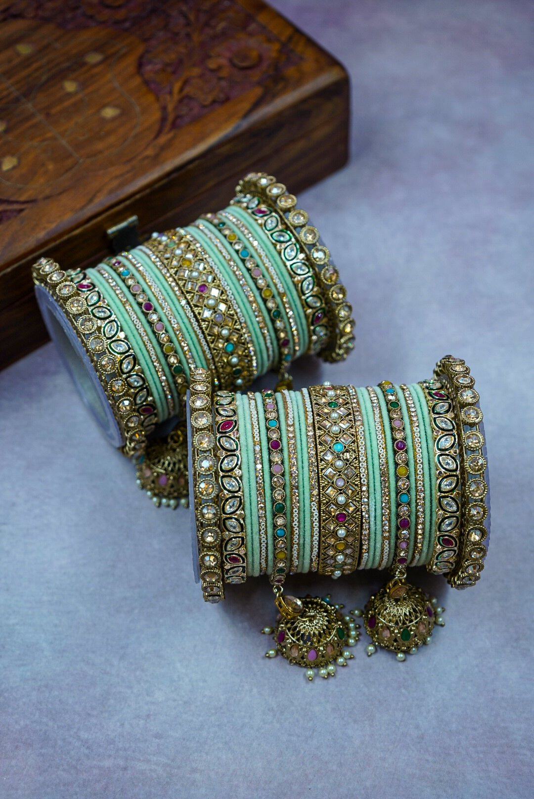Decorative bangles with intricate designs on a textured surface by hitesh bangles
