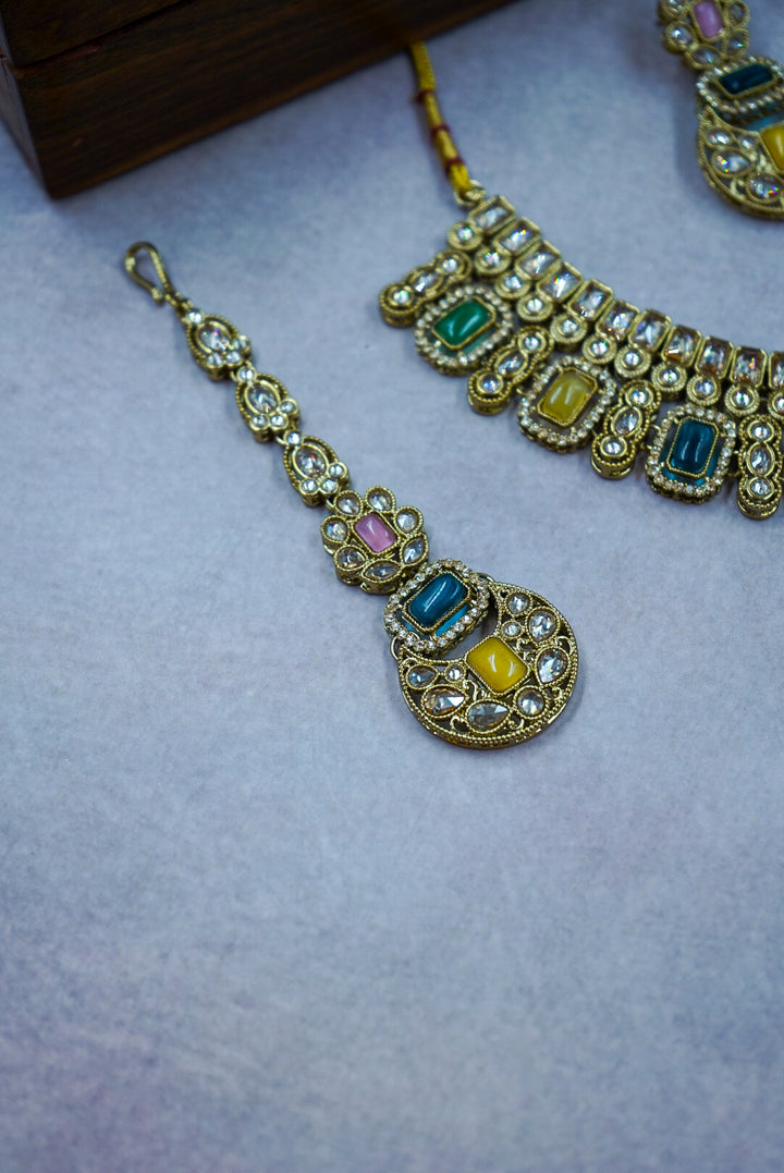 Ornate jewelry set with gemstones on a textured surface by hitesh bangles