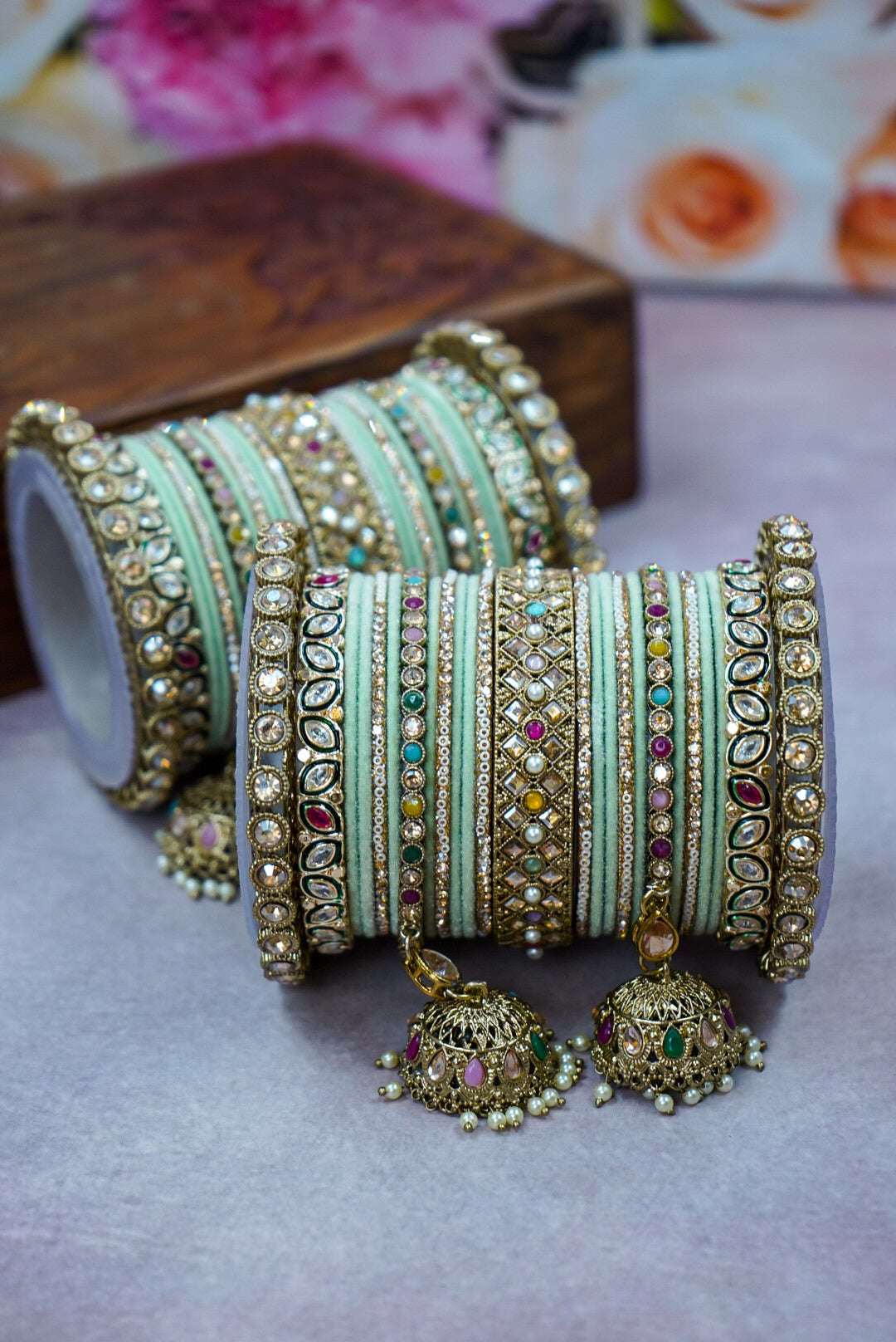 Set of colorful bangles with decorative elements on a light surface by hitesh bangles