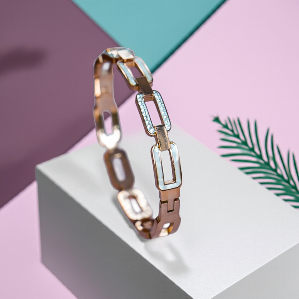 Gold and silver chain bracelet on a geometric background with a palm leaf by hitesh bangles