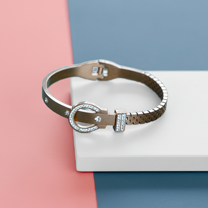 Silver bracelet with a decorative clasp on a pink and blue background by hitesh bangles