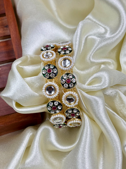 Decorative bangles with gemstones on a white fabric background by hitesh bangles