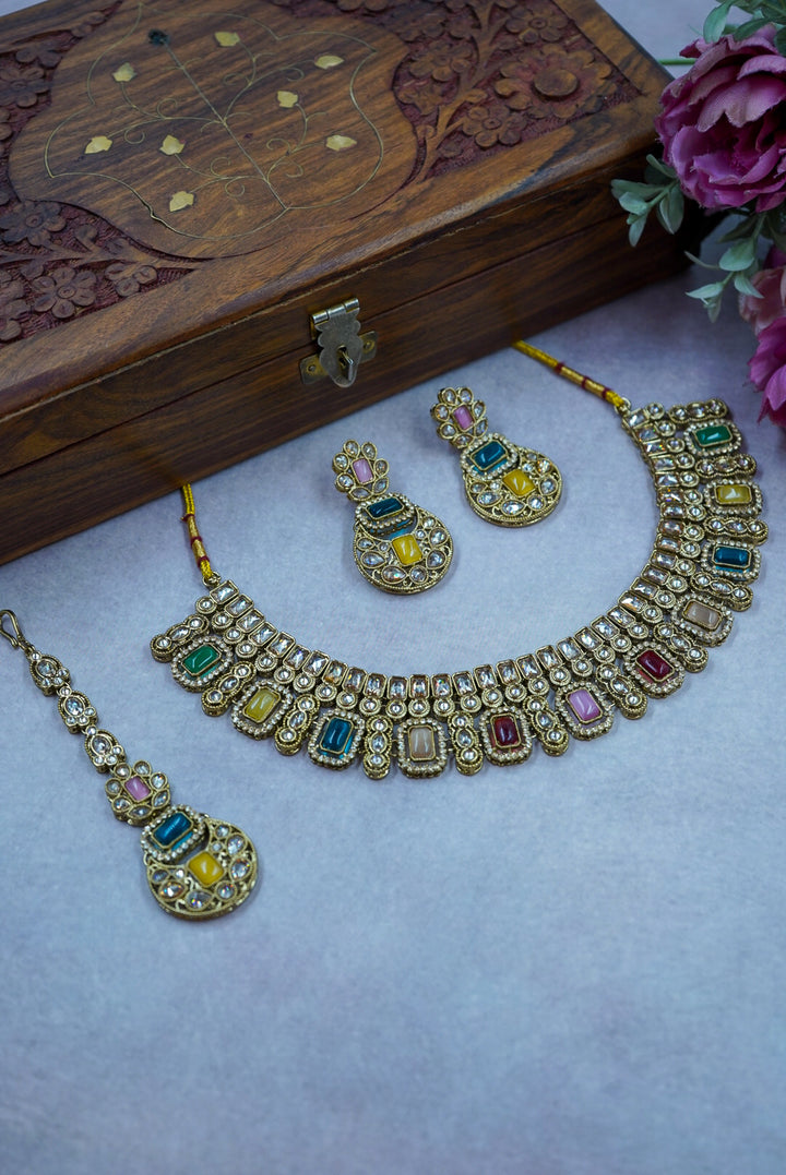 Jewelry set with necklace, earrings, and bracelet on a light purple surface with a wooden box and flowers in the background by hitesh bangles