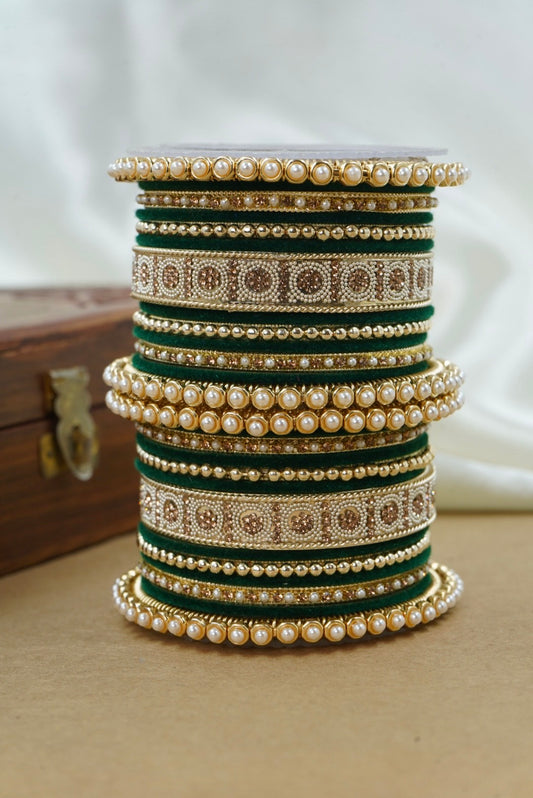 Stack of decorative bangles with pearls and gold accents on a neutral background by hitesh bangles