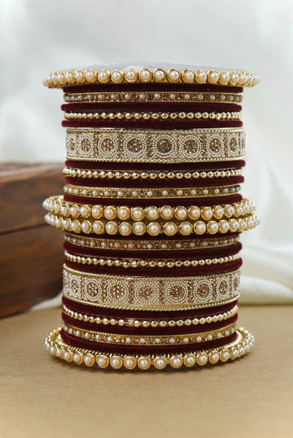 Stack of decorative bangles with pearls and gold accents on a neutral background by hitesh bangles
