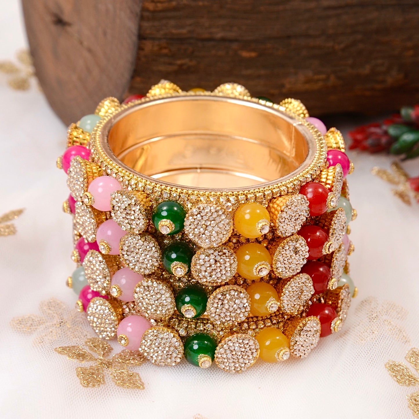 Gold bangle with colorful beads on a white background by hitesh bangles