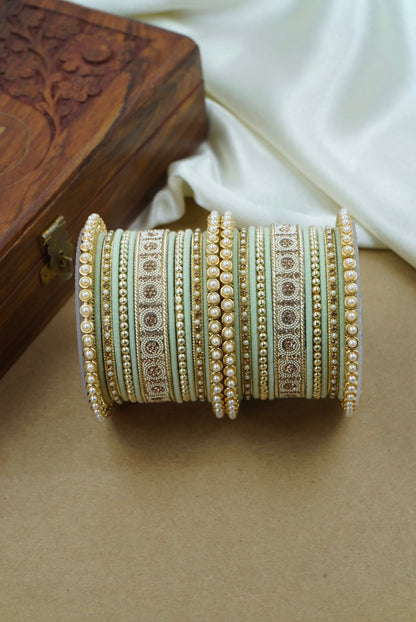 Decorative bangles on a beige surface with a wooden box in the background by hitesh bangles