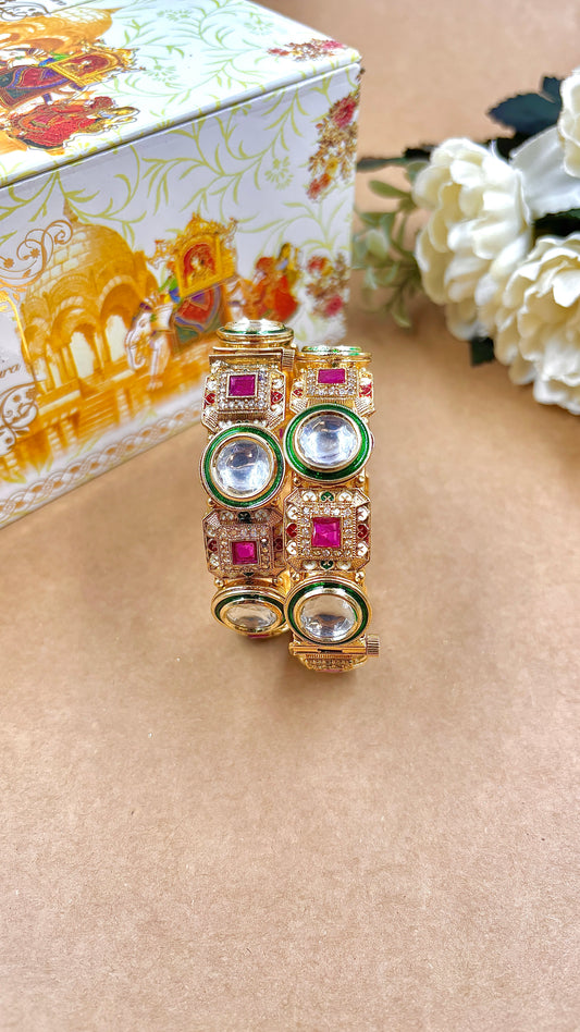 Decorative bangles with gemstones on a beige surface, with a decorative box in the background by hitesh bangles