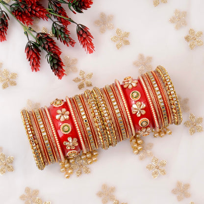 Decorative red and gold bangles with flowers and snowflakes on a light background by hitesh bangles