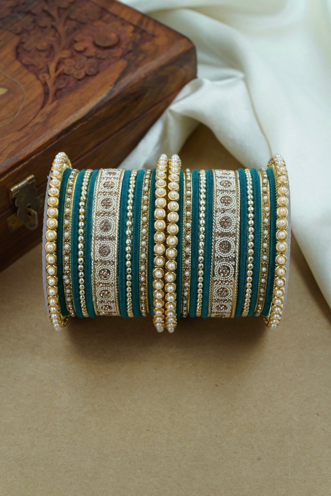 Decorative bangles with intricate patterns on a beige surface by hitesh bangles