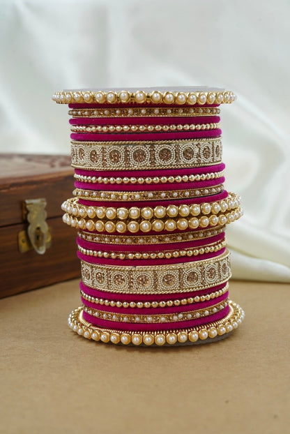 Stack of colorful bangles on a wooden surface with a white background by hitesh bangles