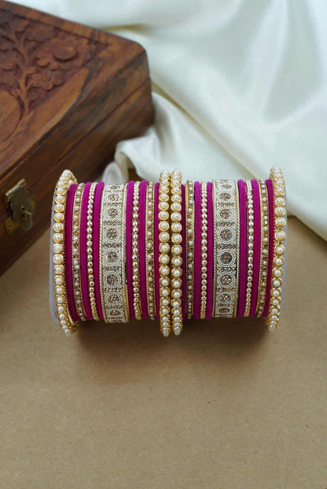 Decorative bangles with intricate designs on a neutral background by hitesh bangles
