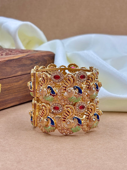 Decorative gold bracelet with gemstones on a beige surface by hitesh bangles