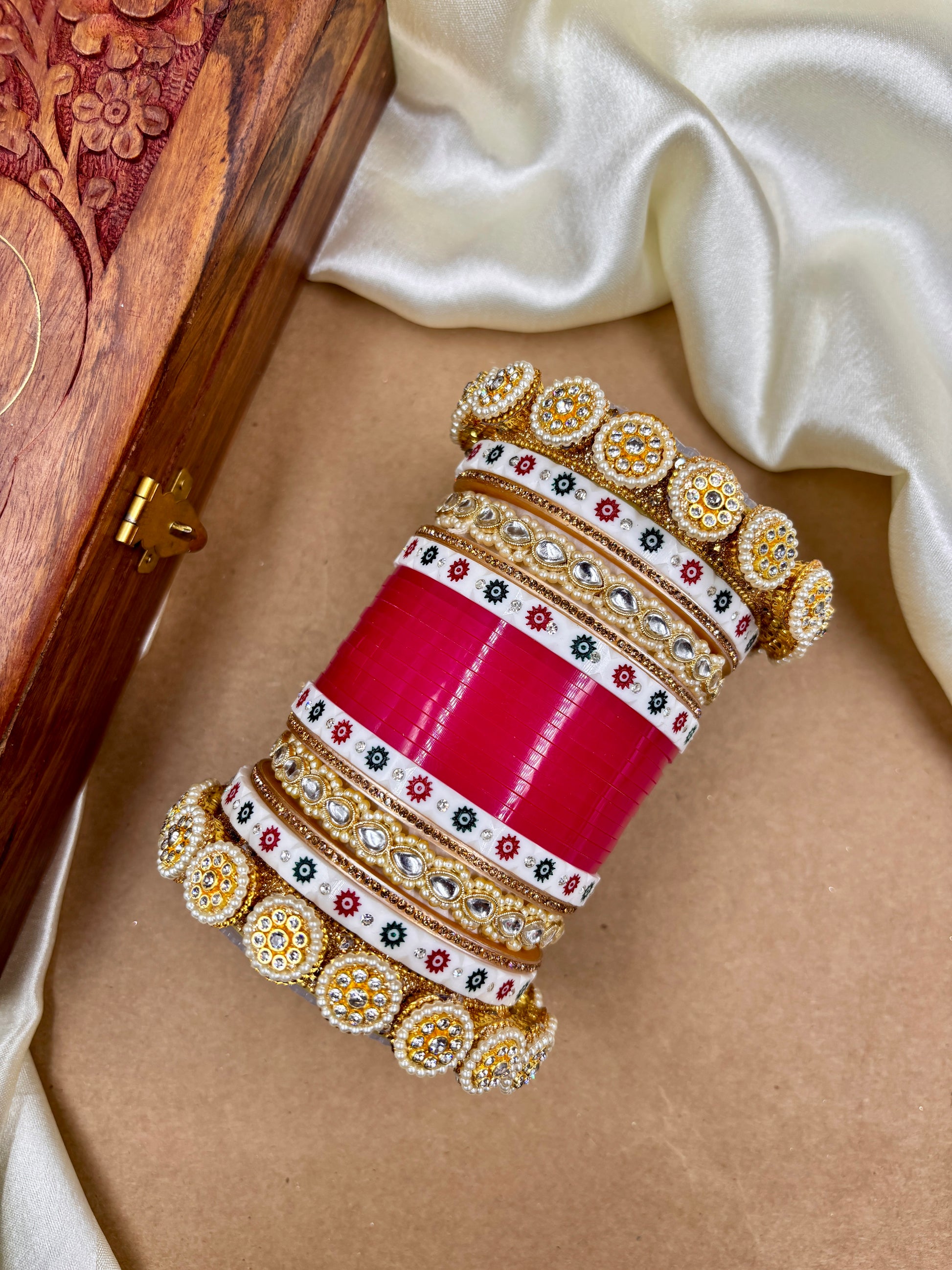 Decorative bangles with intricate designs on a beige surface by hitesh bangles
