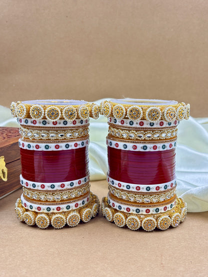 Decorative red containers with gold and white embellishments on a beige background by hitesh bangles