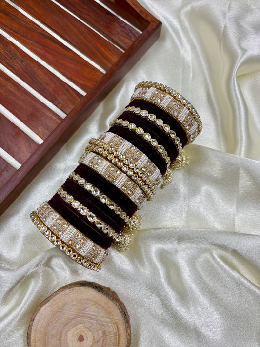 Set of black and gold bangles on a white fabric background by hitesh bangles