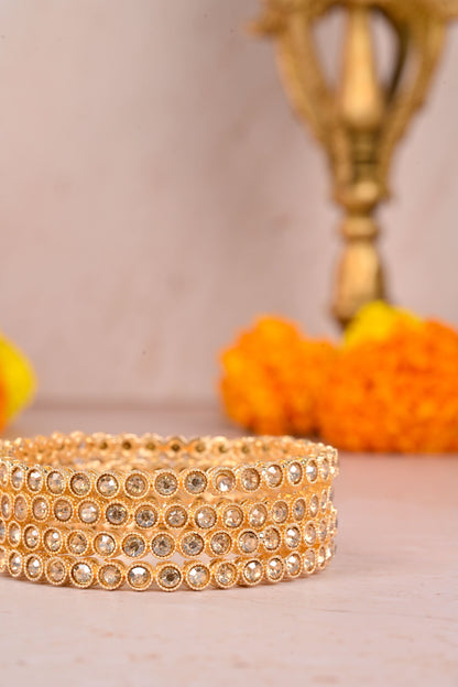 Gold bracelet with crystal detailing on a light background by hitesh bangles