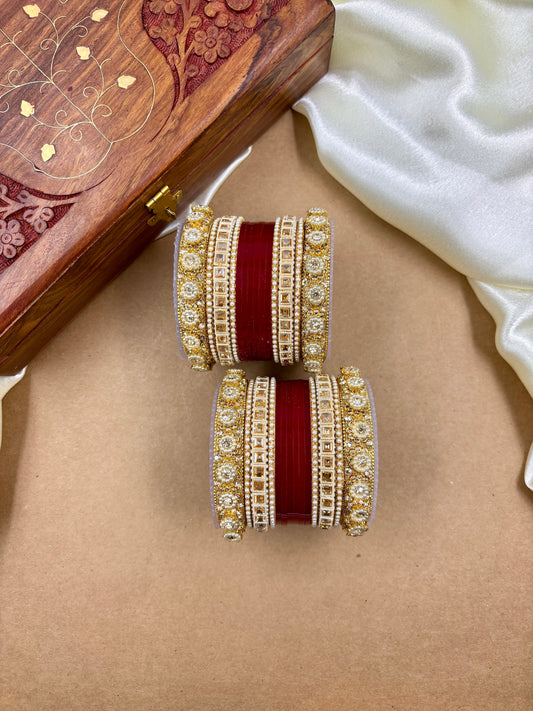 Pair of traditional red and gold bridal bangles with intricate stone detailing by hitesh bangles