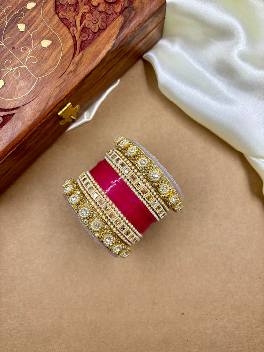 Decorative ring with red center and gold band on a brown surface by hitesh bangles