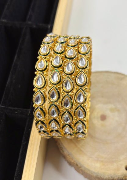 Gold bracelet with diamond-like stones on a wooden surface by hitesh bangles