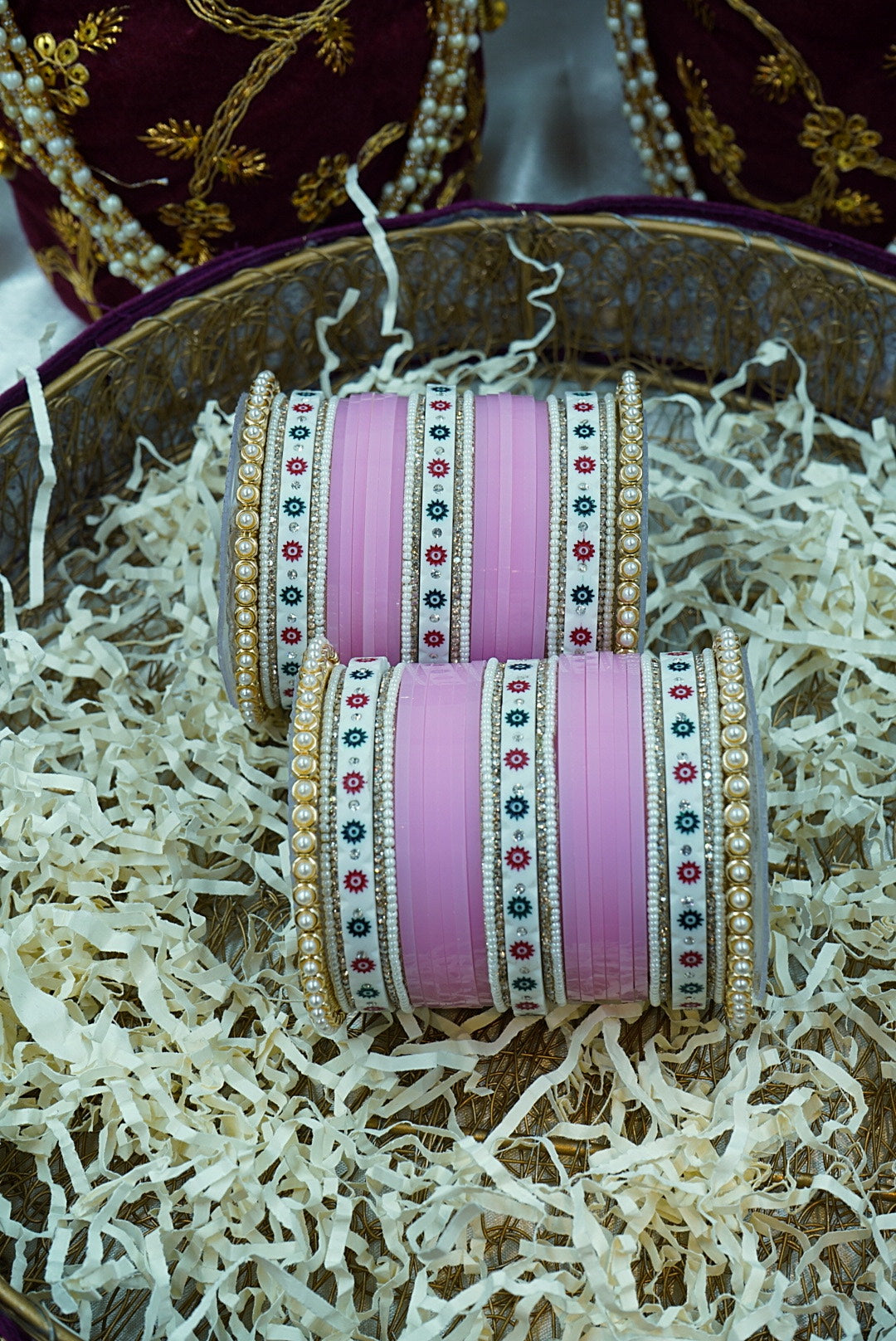 Pink bangles with decorative patterns on a textured surface by hitesh bangles