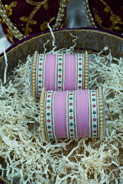 Pink bangles with decorative patterns on a textured surface by hitesh bangles