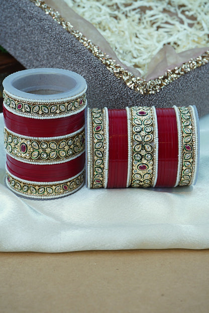 Decorative red and gold bangles on a white fabric background by hitesh bangles