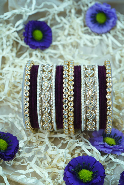 Set of decorative bangles with purple flowers on a textured white background by hitesh bangles