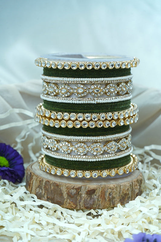 Stack of green bangles with gold and silver embellishments on a wooden block by hitesh bangles