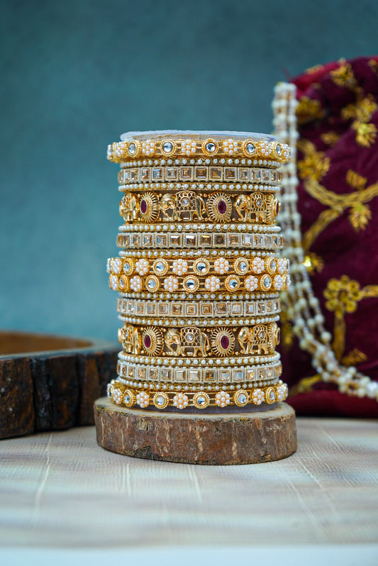 Stack of gold bangles with intricate designs on a wooden stand against a blurred background by hitesh bangles