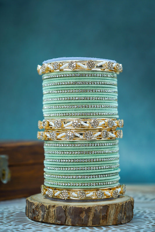 Stack of bangles on a wooden stand with a blue background by hitesh bangles