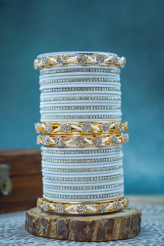 Stack of decorative bangles on a wooden stand with a blue background by hitesh bangles