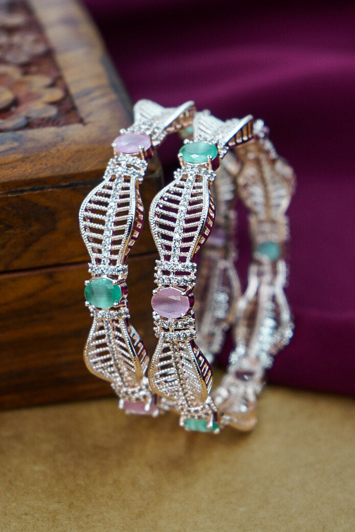 Three decorative bracelets with gemstones on a wooden surface by hitesh bangles