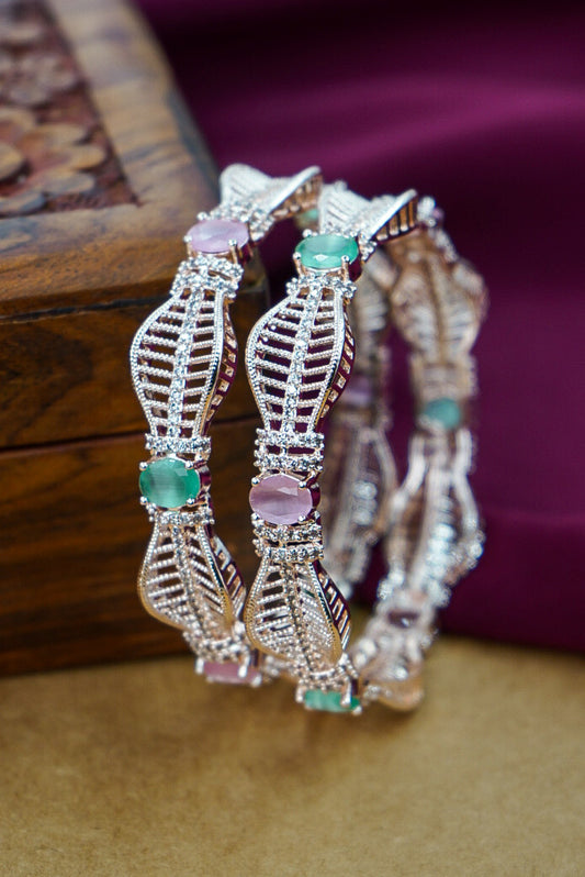 Three decorative bracelets with gemstones on a wooden surface by hitesh bangles