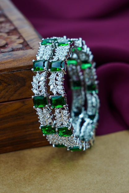 Decorative green and silver bracelet on a textured surface with a wooden box in the background. by hitesh  bangles