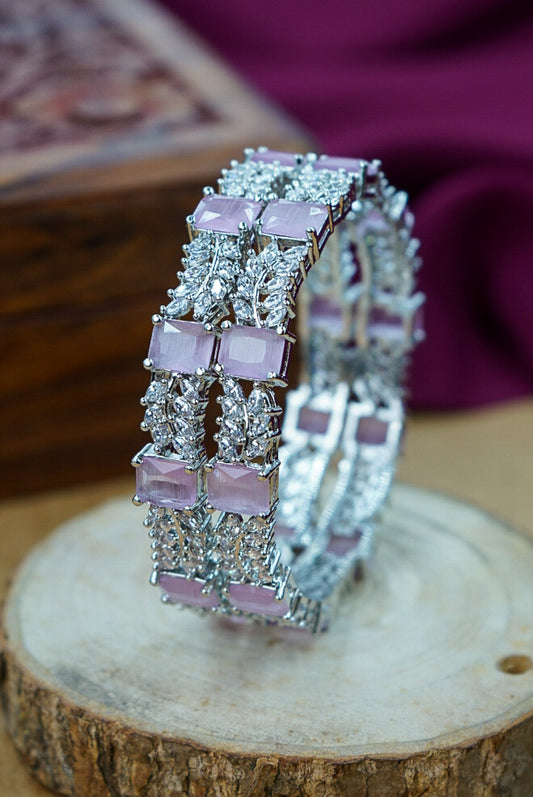 Silver ring with pink gemstones on a wooden surface by hitesh bangles