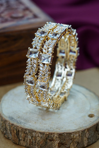 Gold and diamond-studded bangles on a wooden surface by hitesh bangles
