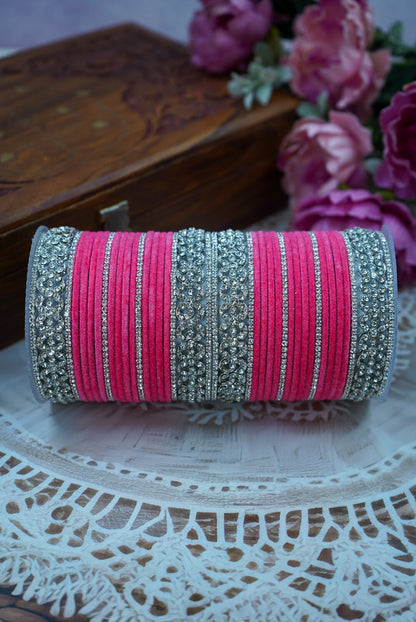 Pink and silver bangles on a decorative plate with flowers in the background by hitesh bangles