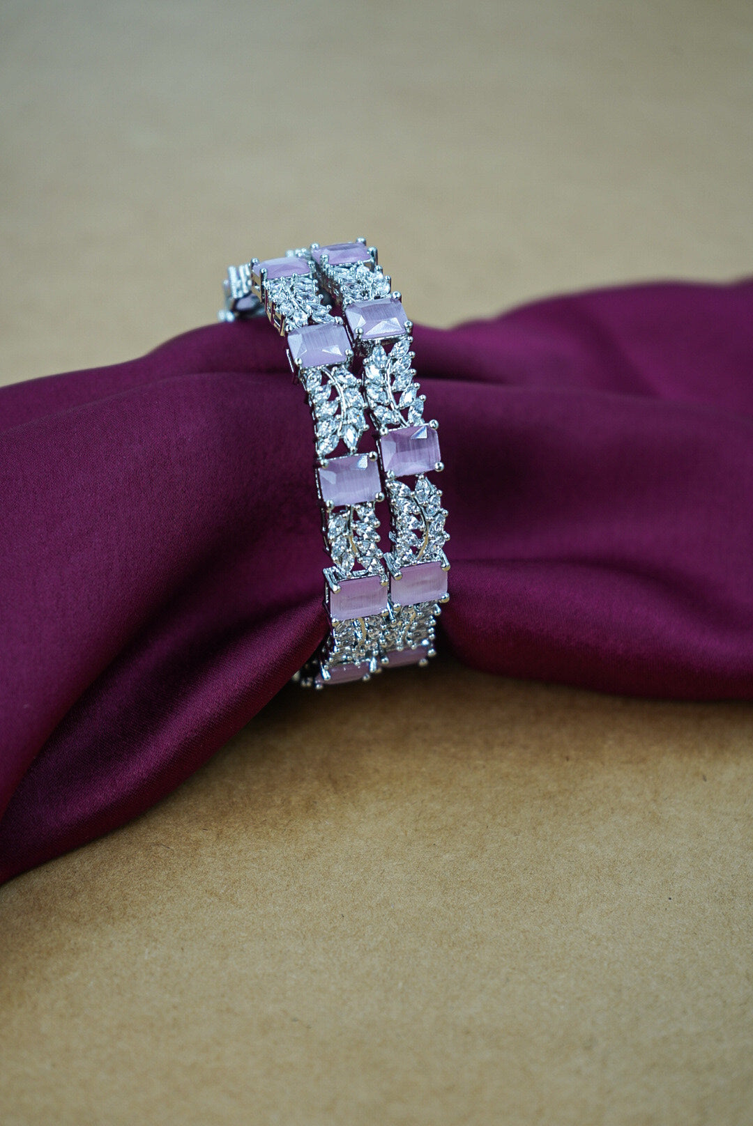 Bracelet with pink stones on a purple fabric background by hitesh bangles
