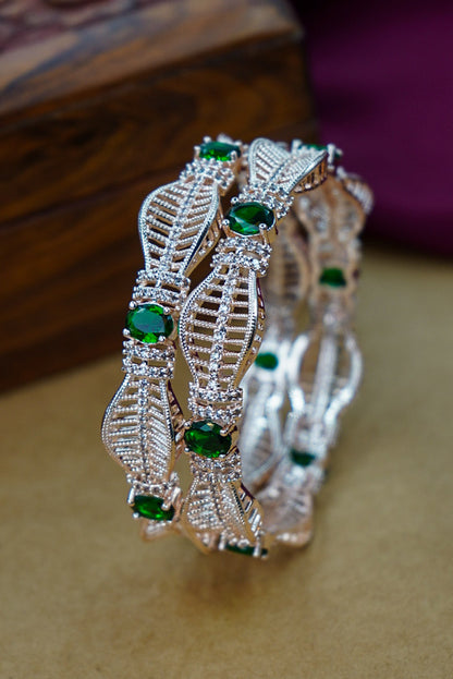 Decorative bracelet with green gemstones on a wooden surface by hitesh bangles